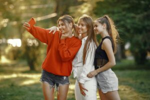 Freunde machen zusammen ein Selfie, das im Fotobuch zum 18. Geburtstag einen Platz finden kann. 